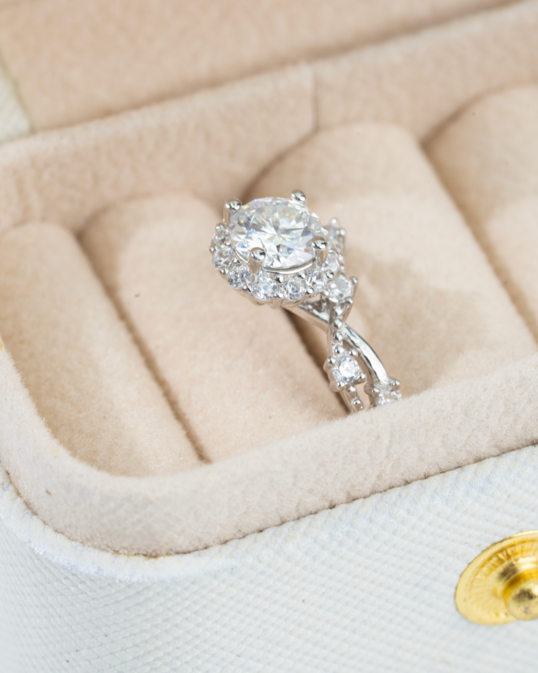 moissanite ring sterling silver in a beige jewelry box with a gold button