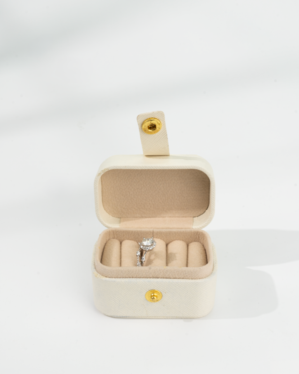 Beige jewelry box with a d color moissanite ring inside 
