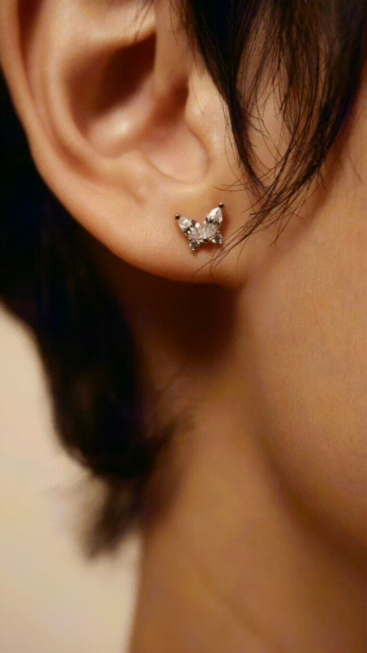 Close-up of JASMINE butterfly ear studs showcasing rhodium finish and cubic zirconia