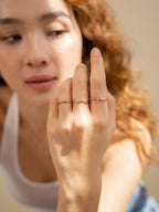 Model wearing three different ring designs on one hand.
