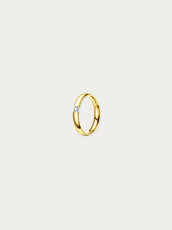 Gold ring with a diamond on a light gray background