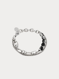 A silver-toned multi-strand chain bracelet featuring textured beaded links, polished oval links, and a row of dark round stones, displayed on a light gray background.