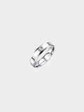 A polished silver band ring with a small, round clear gemstone set on the upper left side, shown against a solid light gray background.