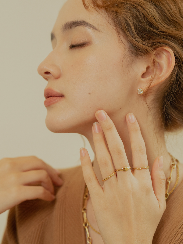 Minimalist gold jewelry: Ondine wave ring paired with a simple band.