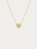 A delicate gold chain necklace featuring a heart-shaped pendant with a polished gold center heart surrounded by a halo of small clear stones, set against a solid light gray background.