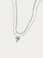 Amora Double Layered Necklace in silver titanium with paperclip chain, fine chain, and heart pendant, studio hero shot