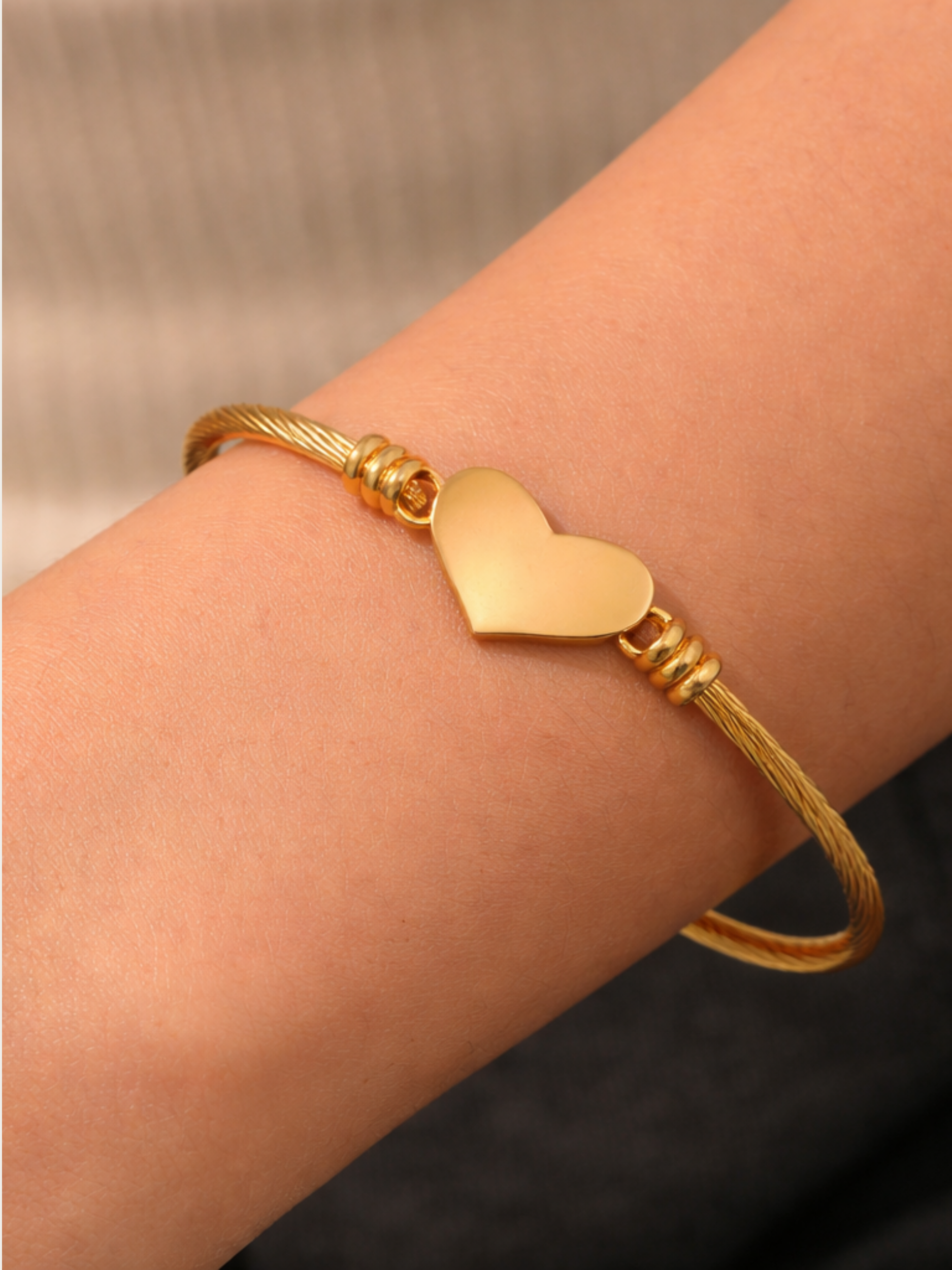 Close-up of polished gold heart charm on Amour Cable Heart Engravable Bracelet