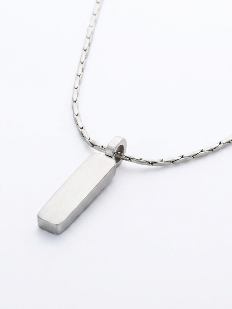Macro detail of Axis rectangular pendant in silver titanium on wheat chain
