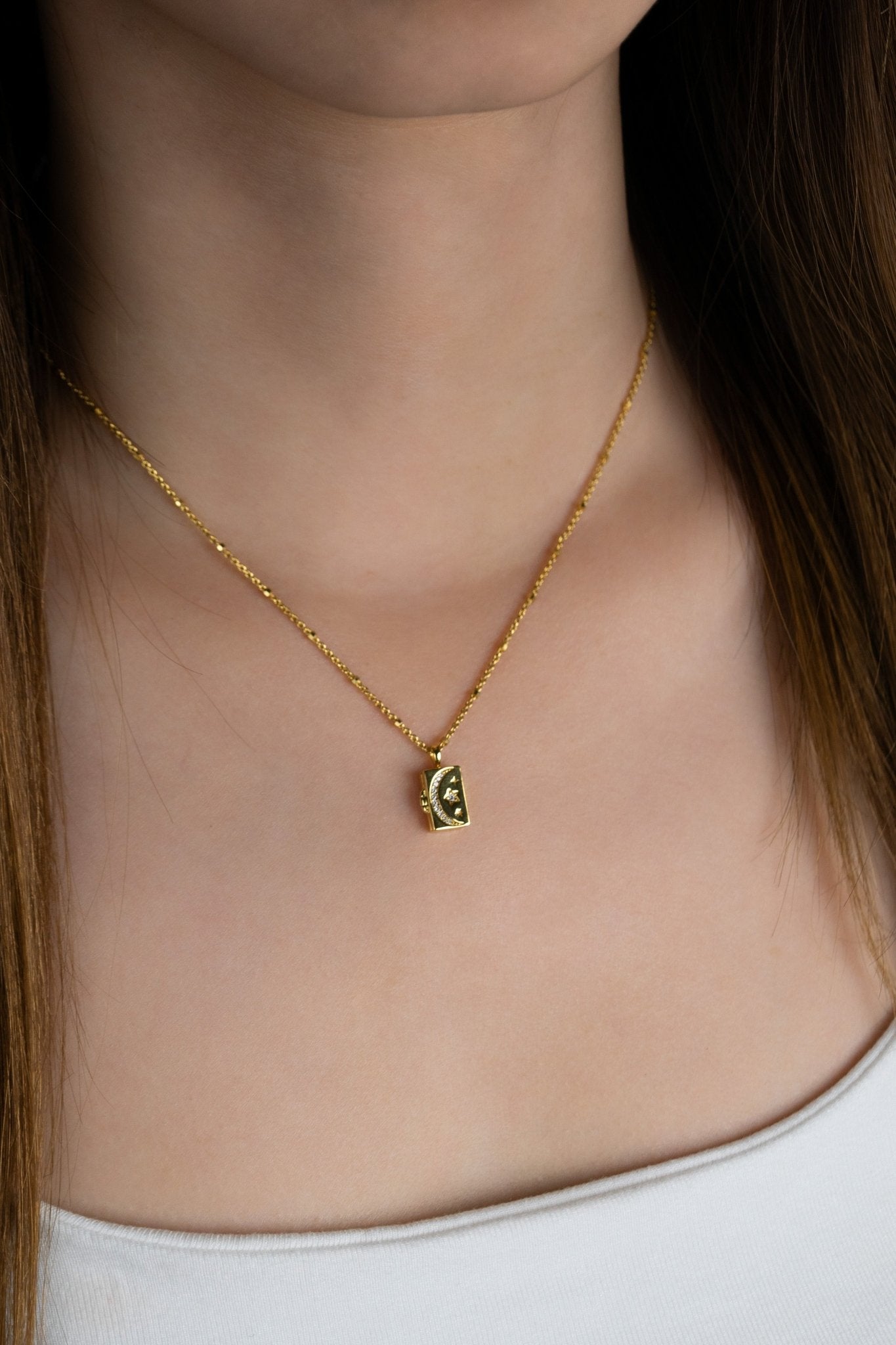 Model wearing CALLISTA Galactic Locket Necklace at the collarbone in gold colour