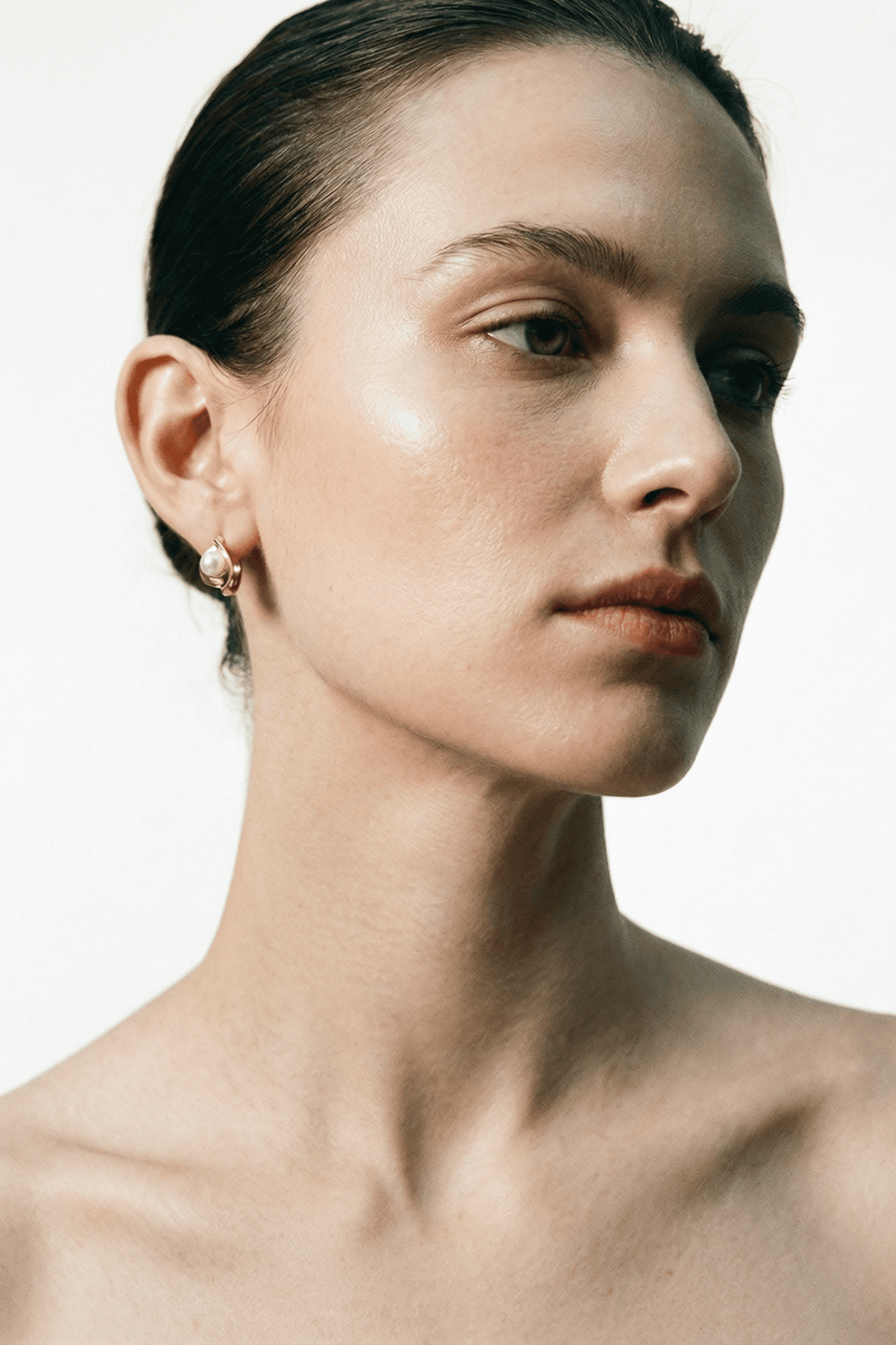 Carina Pearl Huggie Earrings gold tone worn on ear, front view, MNML Malaysia lifestyle shot