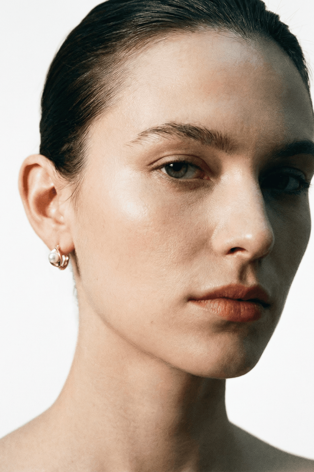 Carina Pearl Huggie Earrings gold tone worn on ear, side profile, MNML Malaysia lifestyle shot