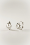 Carina Pearl Huggie Earrings in silver tone stainless steel, sculptural pearl huggie product flatlay