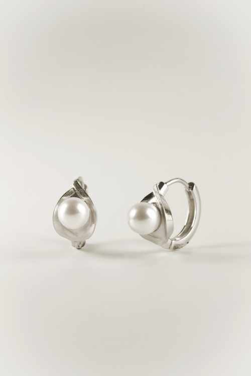 Carina Pearl Huggie Earrings in silver tone stainless steel, sculptural pearl huggie product flatlay