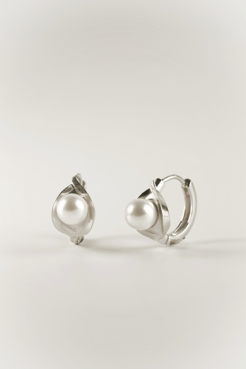 Carina Pearl Huggie Earrings in silver tone stainless steel, sculptural pearl huggie product flatlay