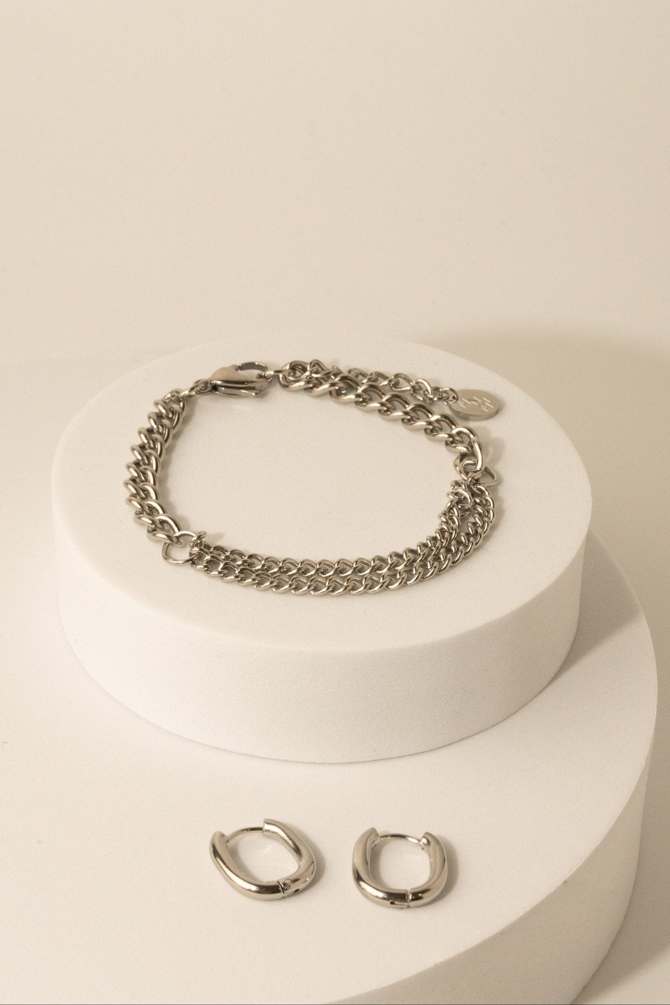 Curb Mixed Layer Chain Bracelet silver tone stainless steel, dual curb chain on white pedestal flatlay