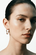sculptural curve earrings worn on ear side view