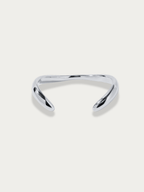 Flow Curved Bangle in silver titanium with fluid sculptural curves, studio hero shot
