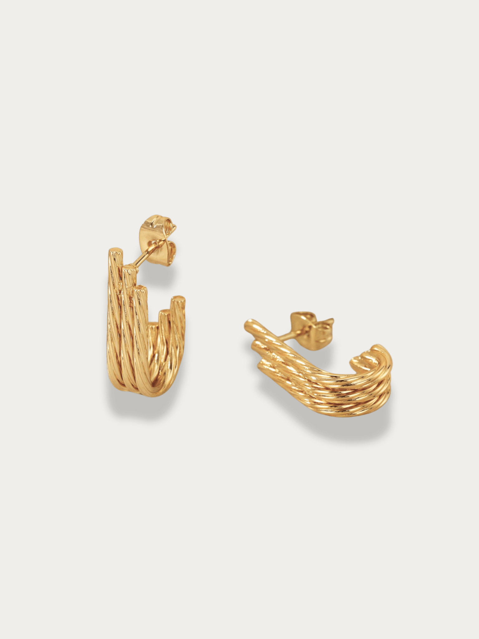 Goldie Twist J-Curve Hoop Earrings gold tone titanium, three twisted cable strands in J-curve, product flatlay
