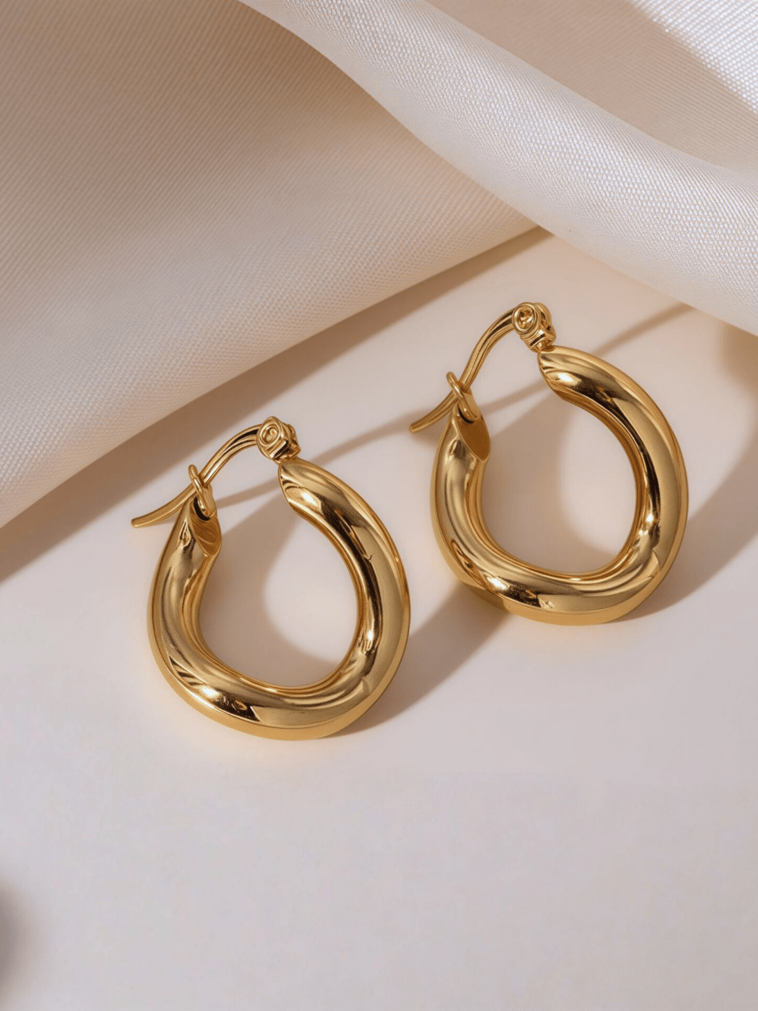 Gwenna Geo Drop Hoops flatlay in gold and silver colourways