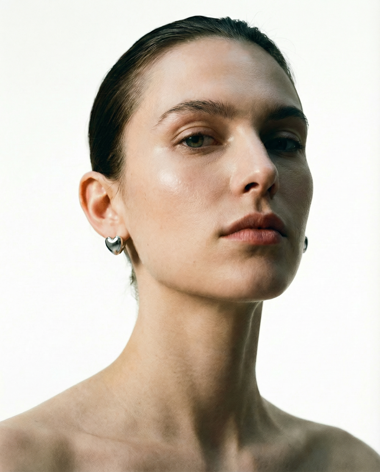 heart huggie earrings worn on ear minimalist style