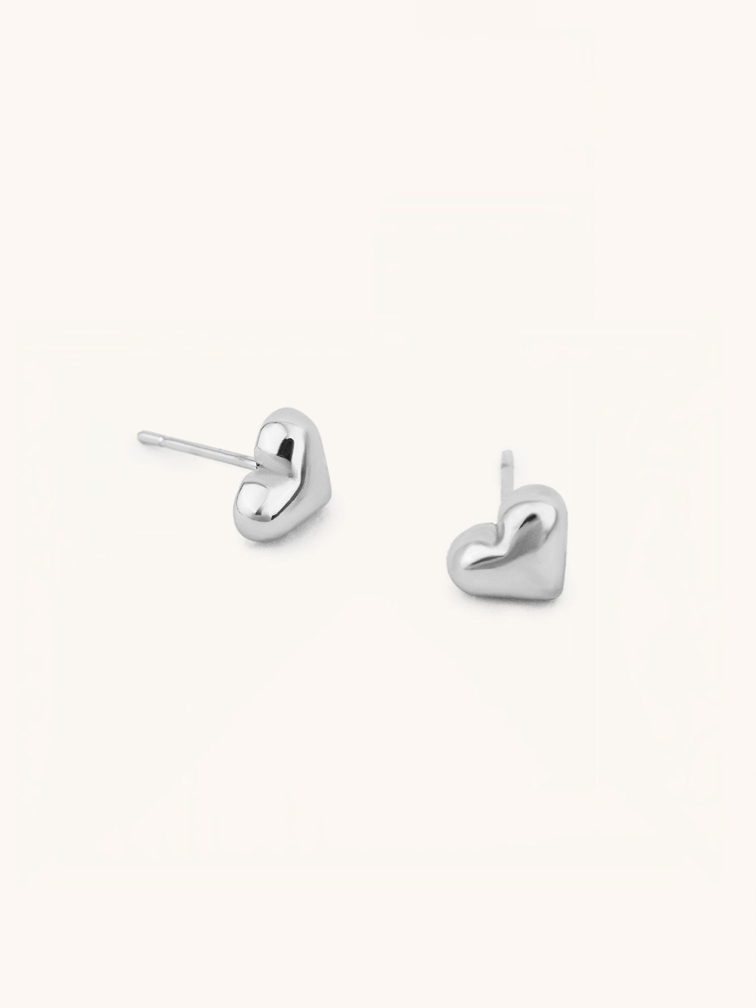 Heart Stud Earrings silver tone stainless steel, puffy 3D heart studs, product flatlay
