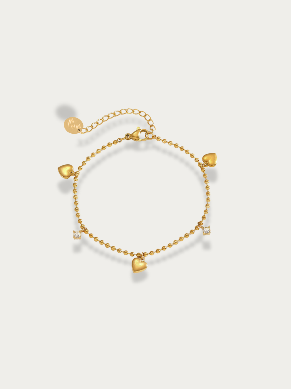 Jaye Heart Charm Bracelet gold tone stainless steel, bead chain with three heart and two CZ charms, product flatlay