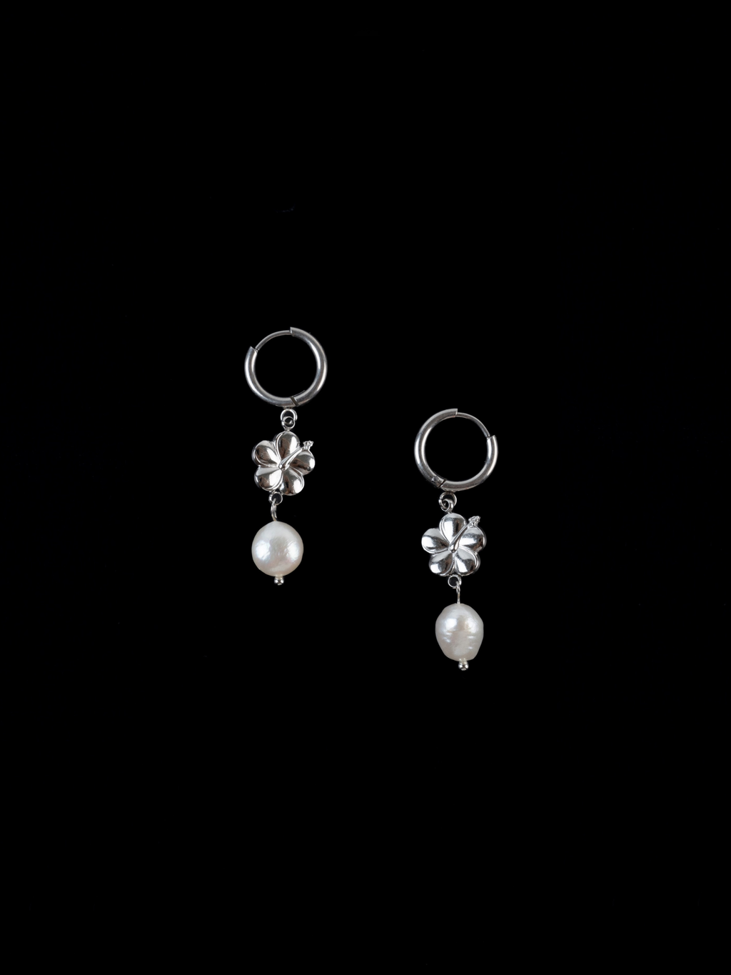 Close-up of hibiscus motif and freshwater pearl on hoop earring
