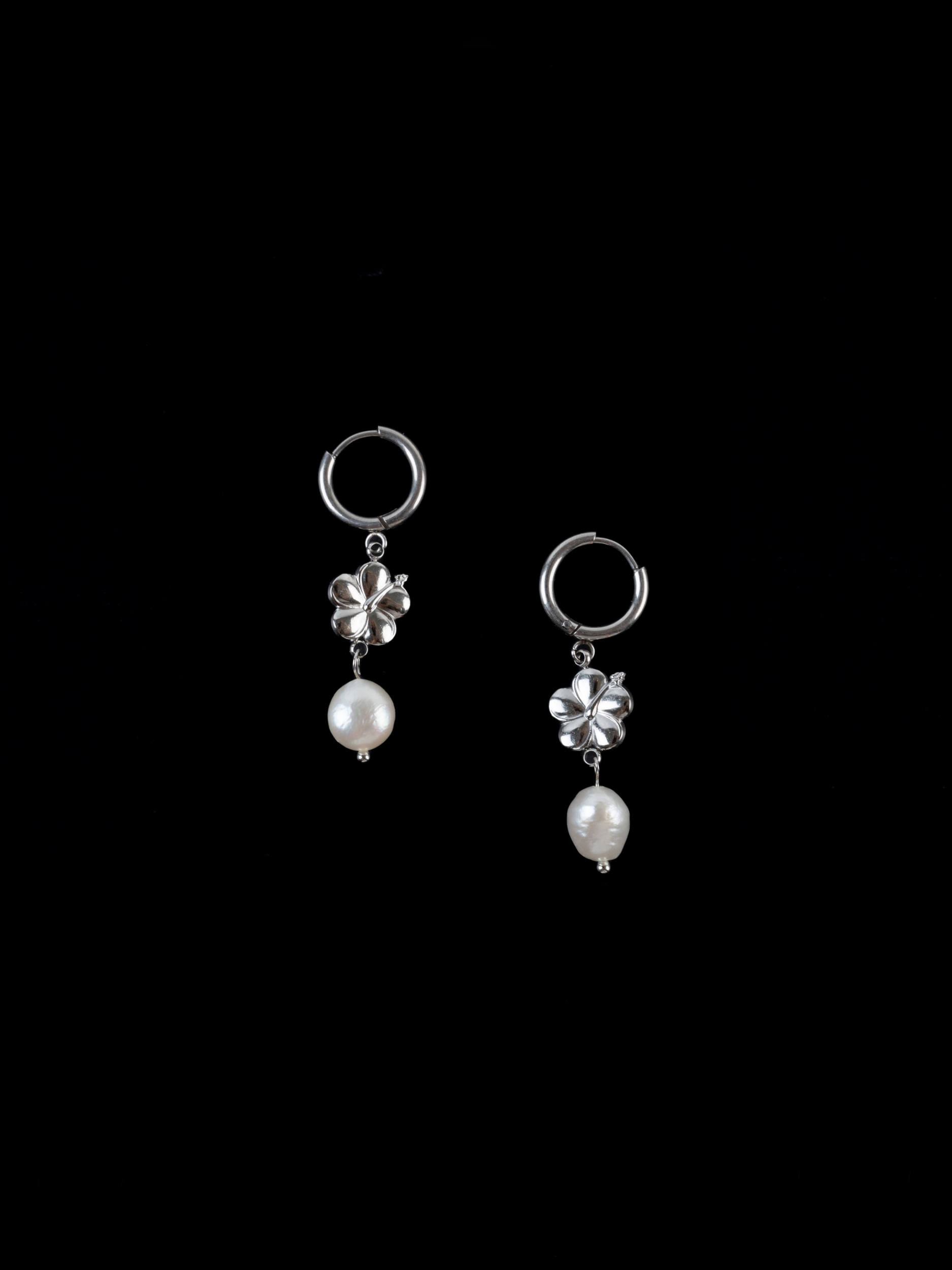 Close-up of hibiscus motif and freshwater pearl on hoop earring