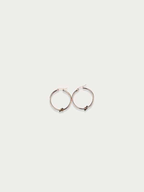 Aria Knot Hoop Earrings in rose gold titanium on a white background.
