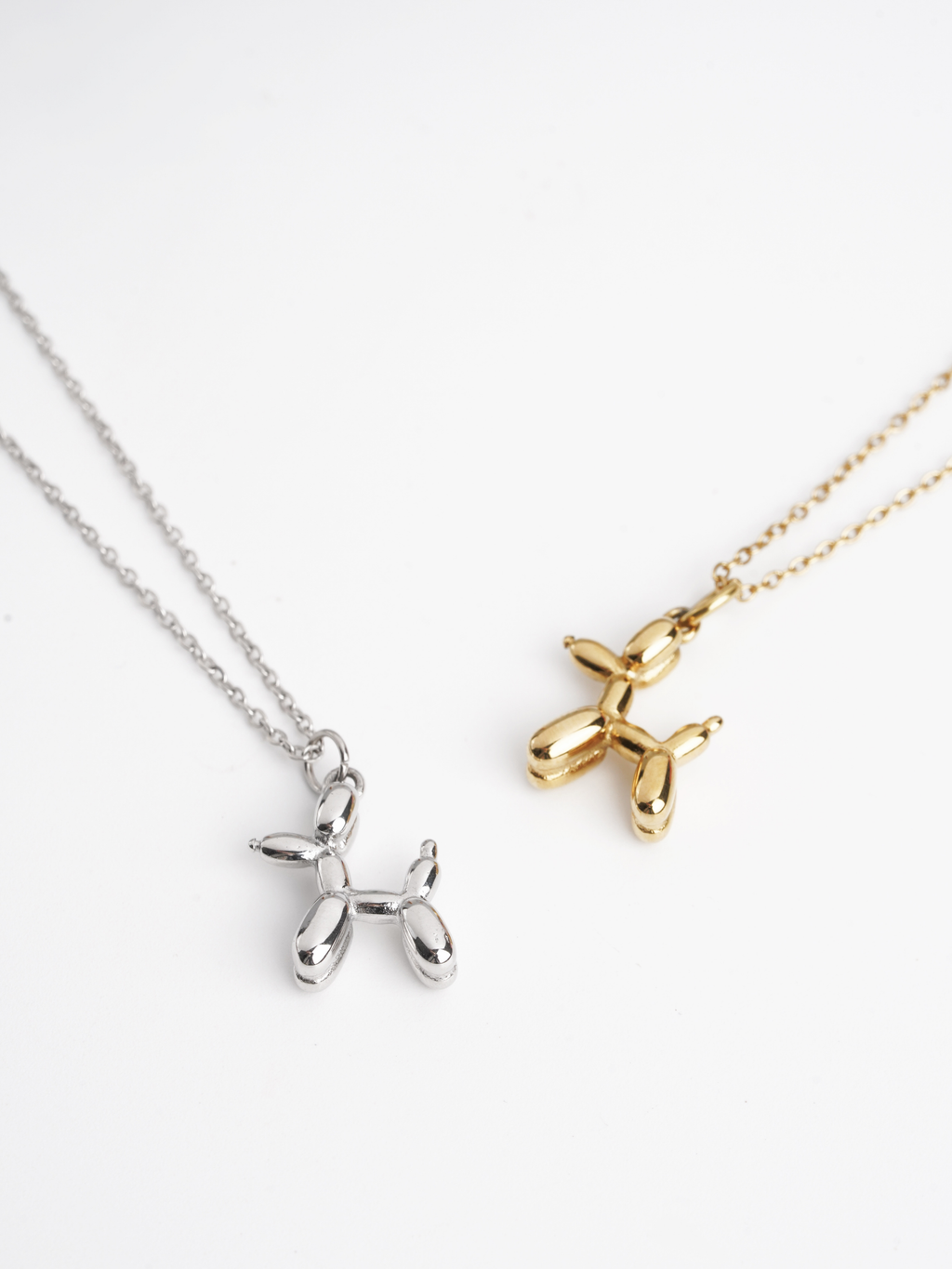 MNML Atelier Balloon Pup Pendant Necklace in silver and gold flat lay — titanium art jewelry Malaysia