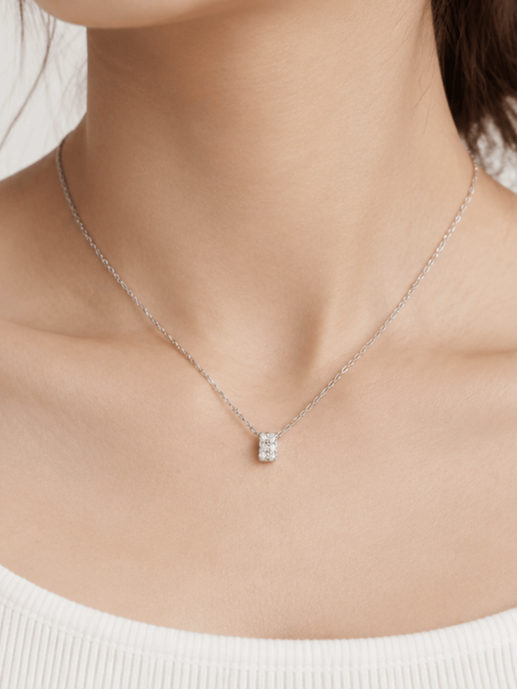 Silver-tone Cielo pendant necklace worn at the base of the neck