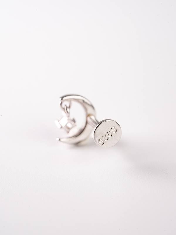 Close-up of crescent moon and suspended star on MNML 925 silver rhodium flatback stud