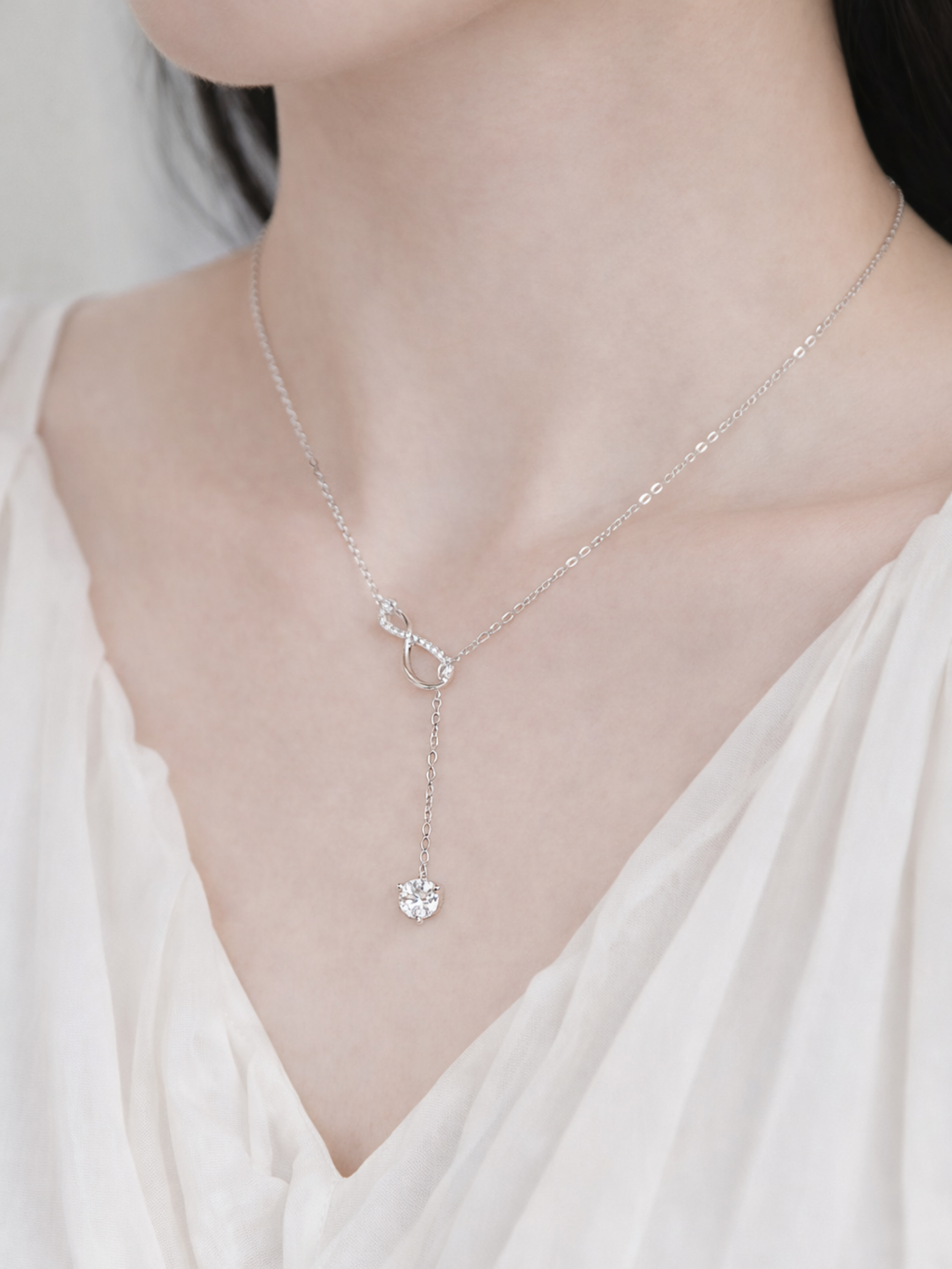 Close-up of pavé infinity symbol on Elyra necklace