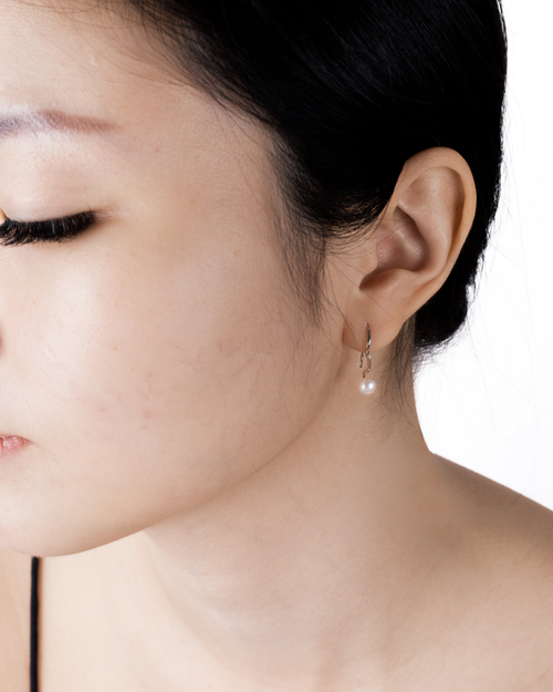 Fluidity wave pearl earring worn on the ear