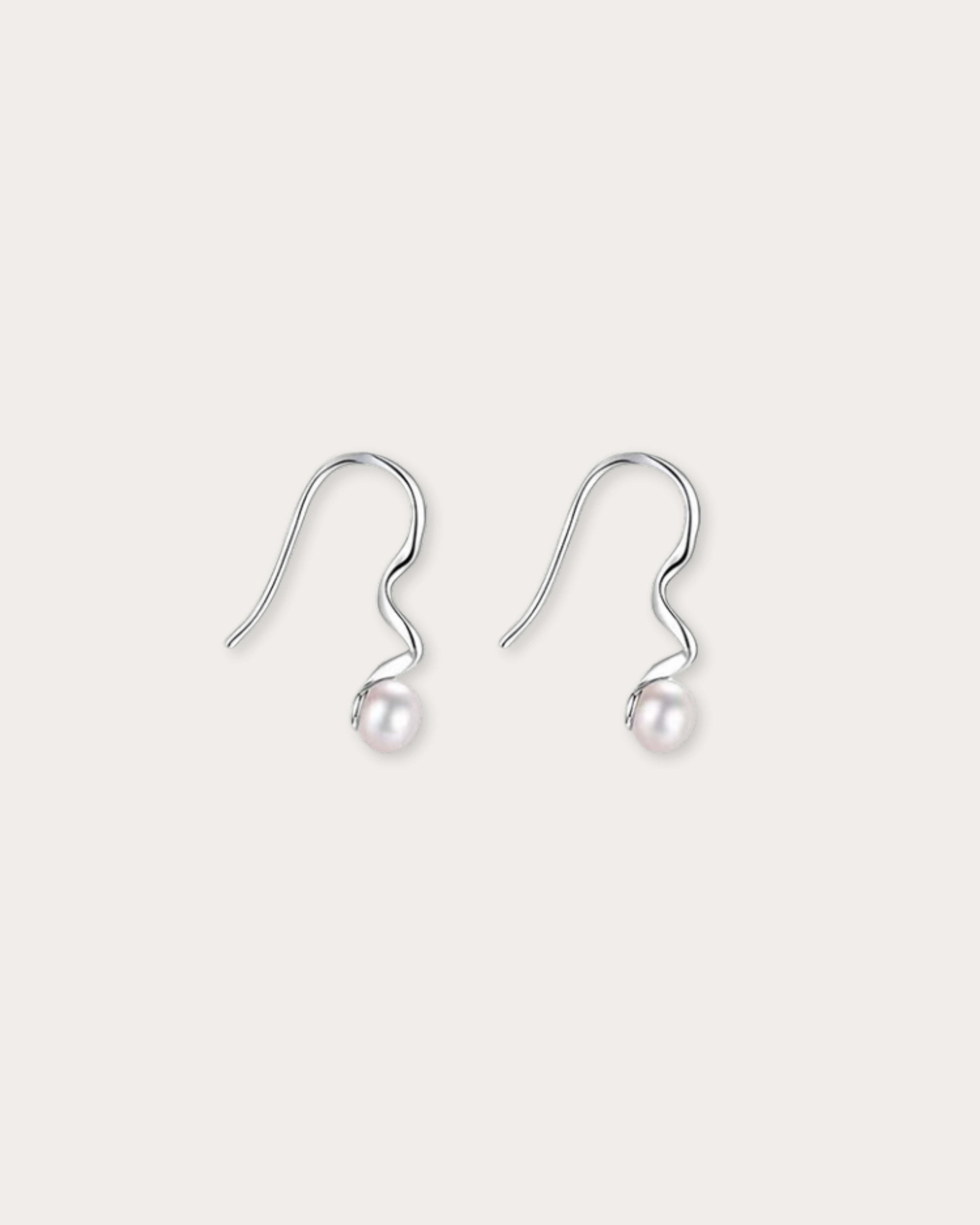 Pair of Fluidity Wave Pearl Drop Earrings laid flat