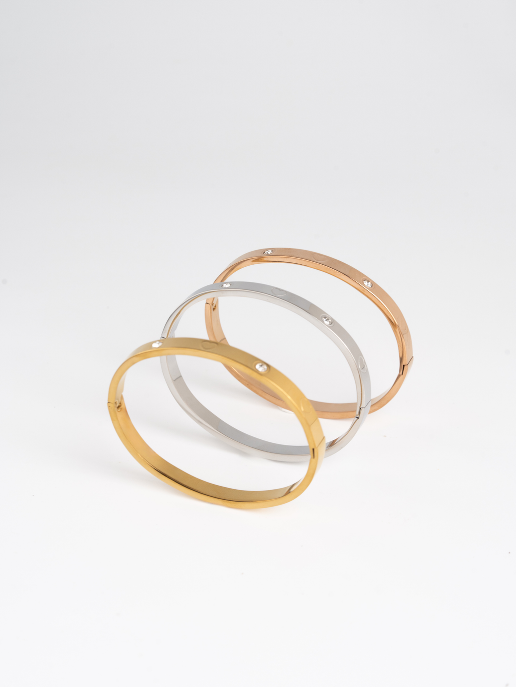 MNML Heart Spark Slim Bangle in silver gold and rose gold flat lay — titanium heart bangle
