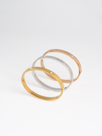 MNML Heart Spark Slim Bangle in silver gold and rose gold flat lay — titanium heart bangle
