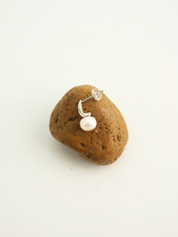 Close-up of natural pearl on Iris earring