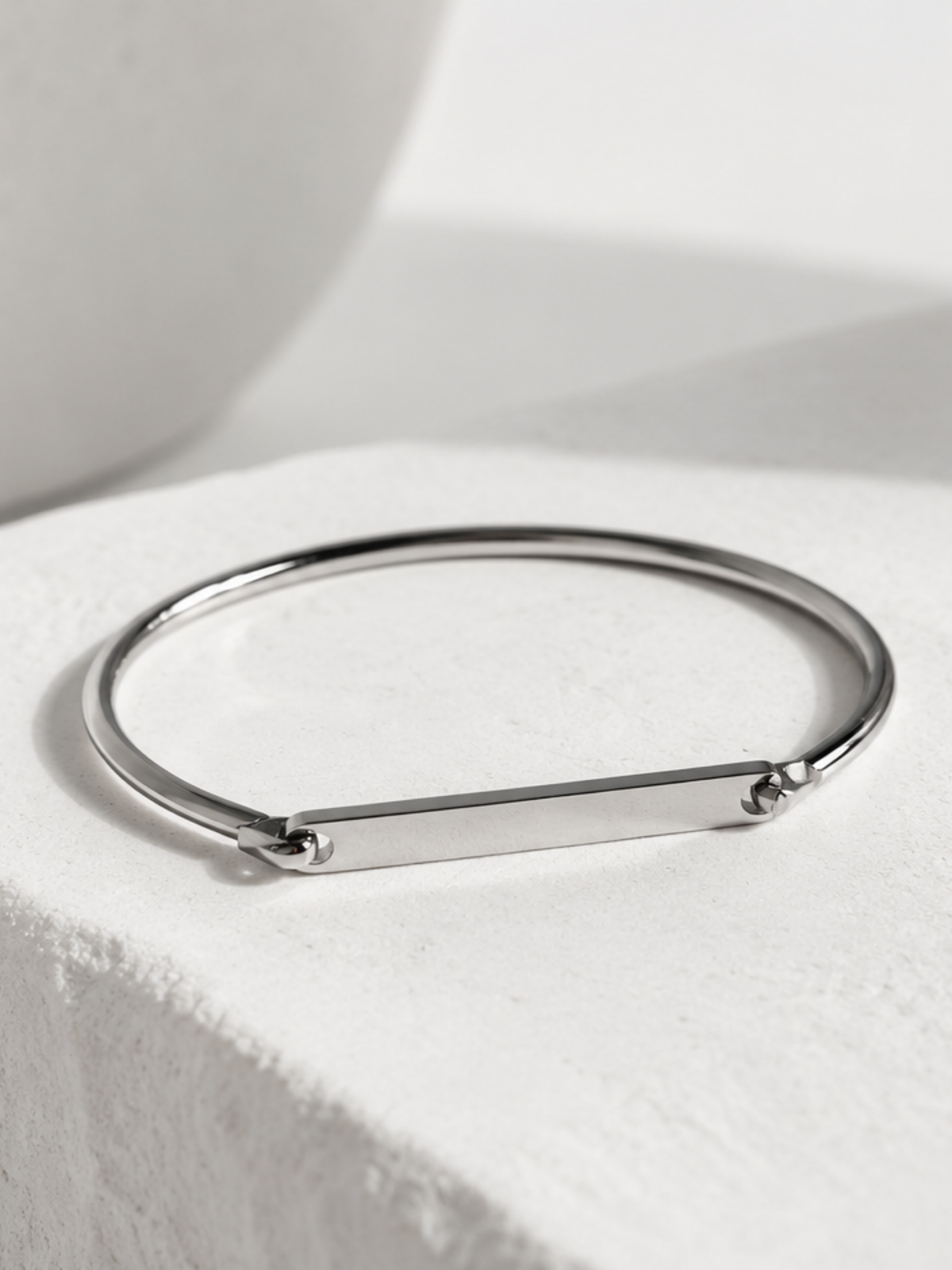 Close-up of a name engraved on the Julius bangle's 4cm bar