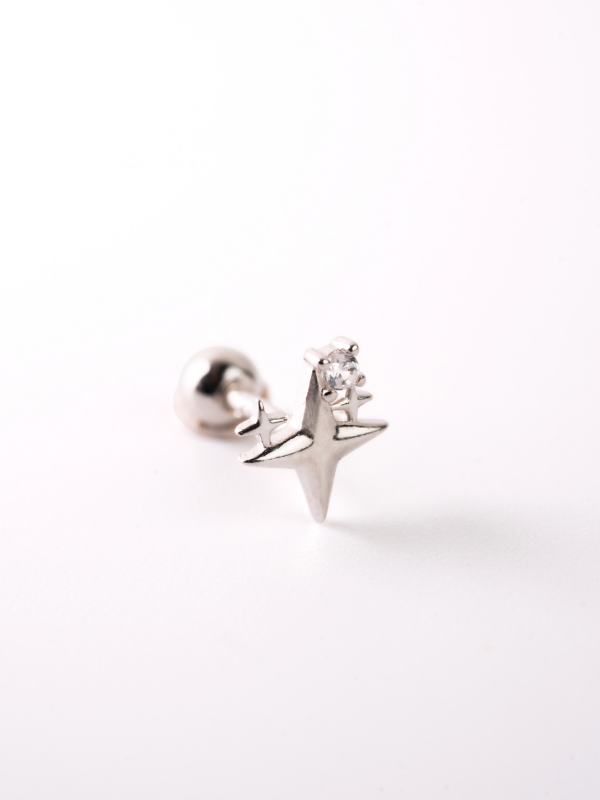 Close-up of starburst silhouette on MNML Kepler 925 silver rhodium barbell stud — celestial detail