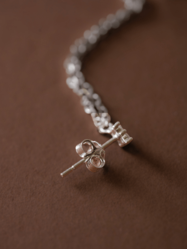 Close-up of double chain detail on MNML Lea 925 silver chain studs — fluid movement