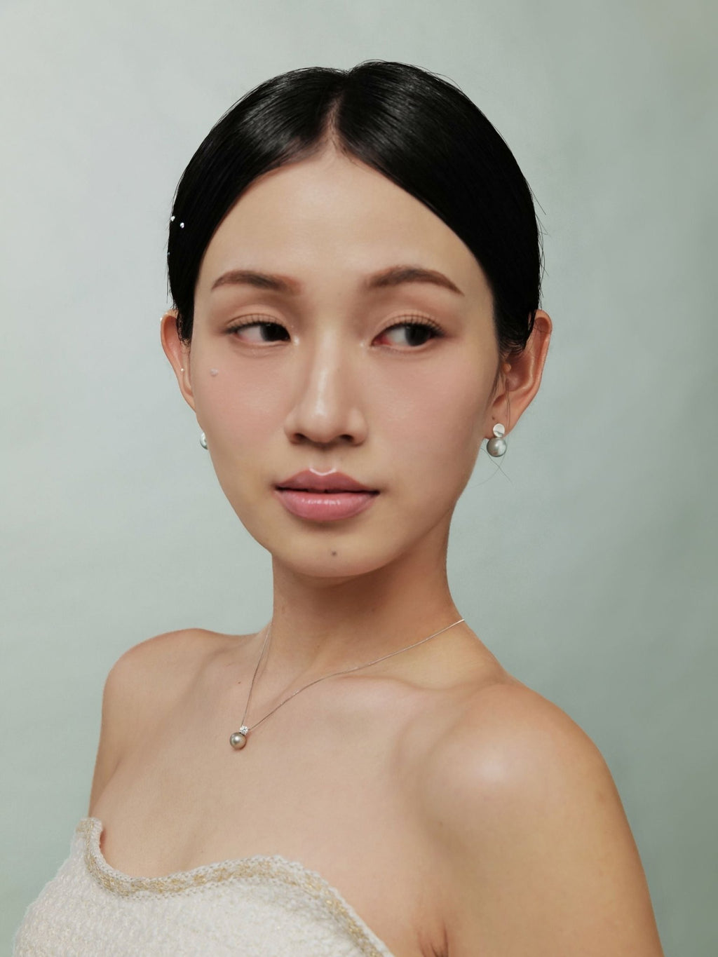 Side view of Luna earring showing silver disc and pearl placement