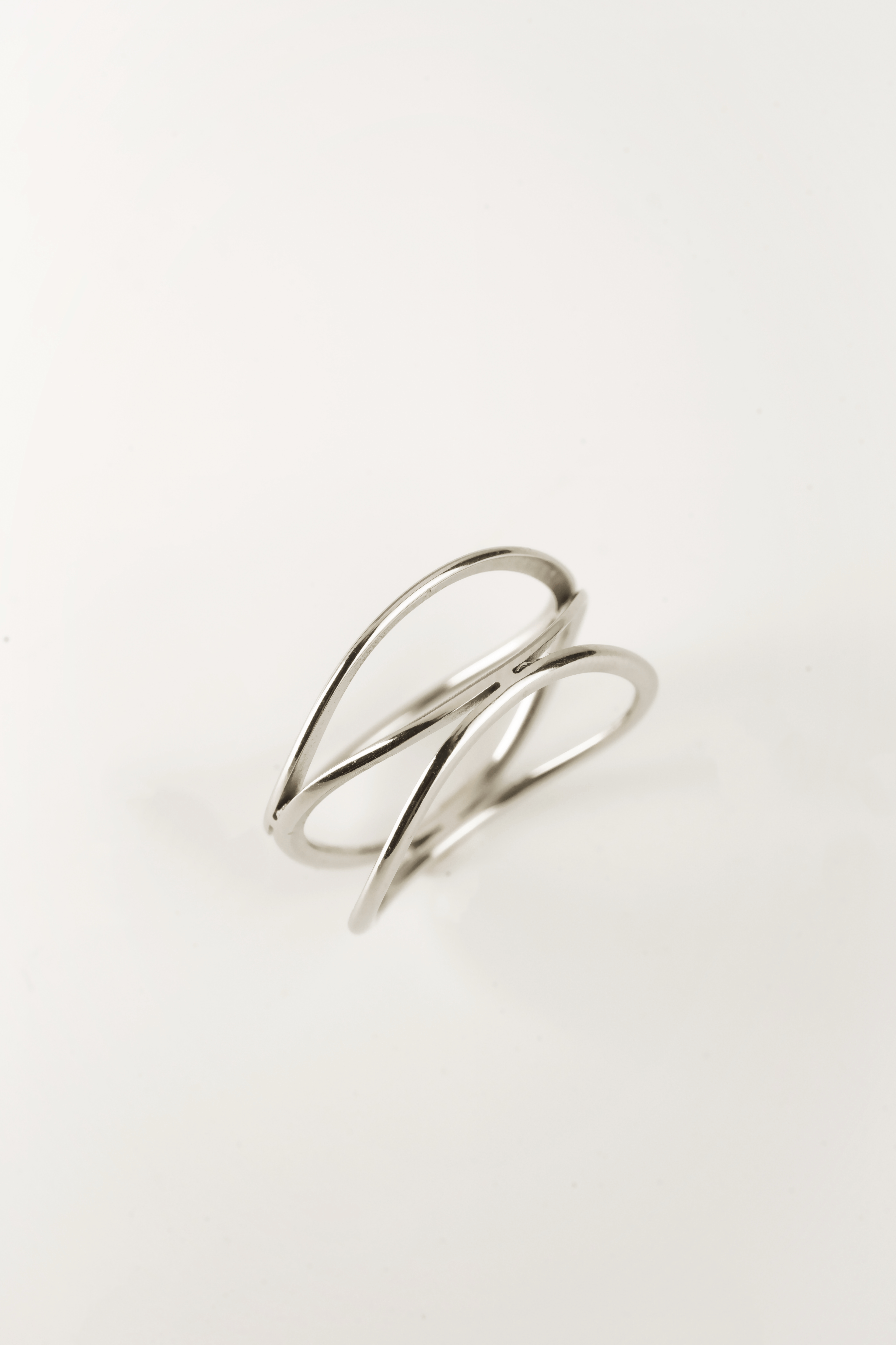 close up intertwined loop silver ring sculptural detail