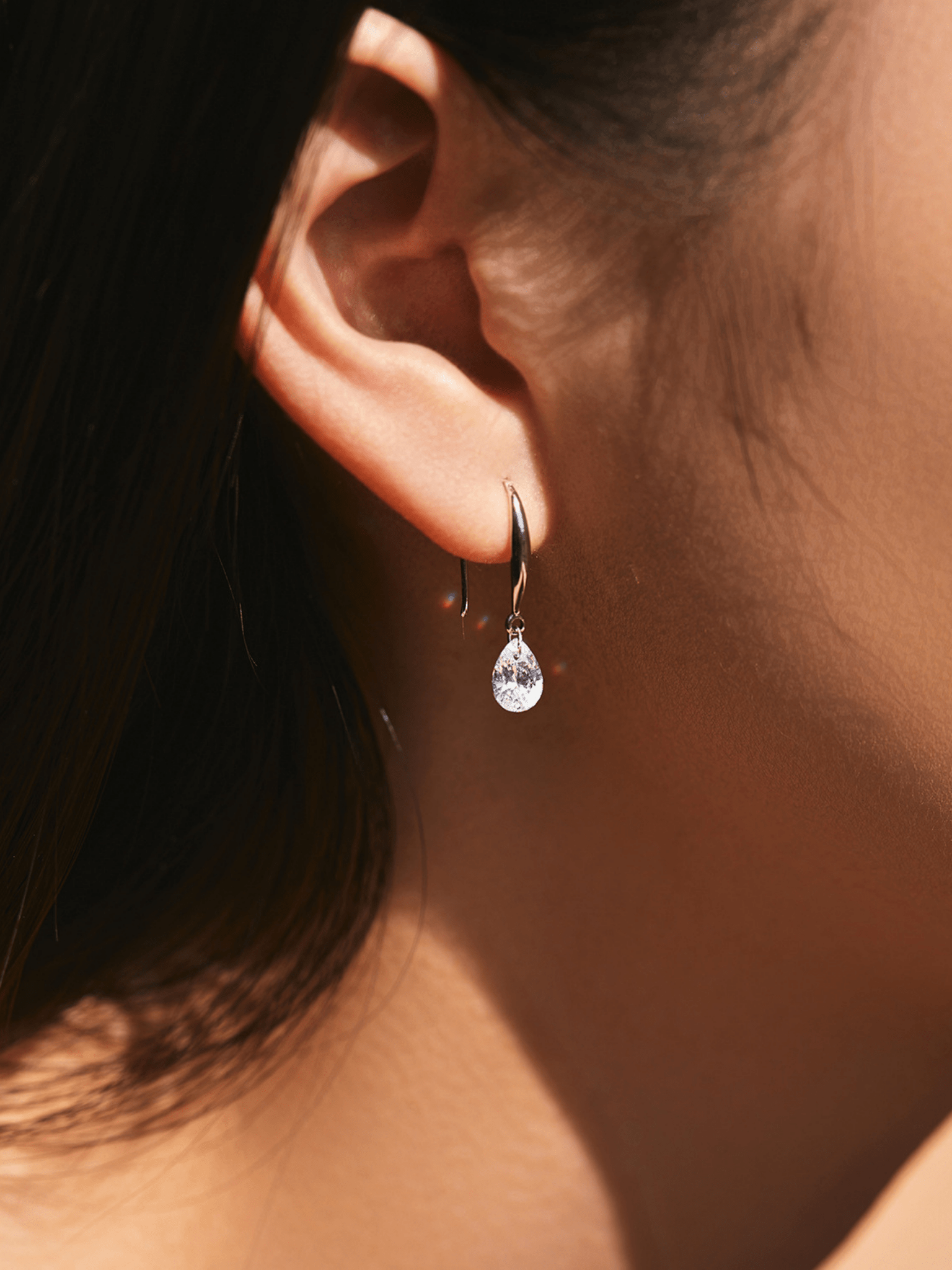 Side view of Pearluxe teardrop earring showing hook and stone