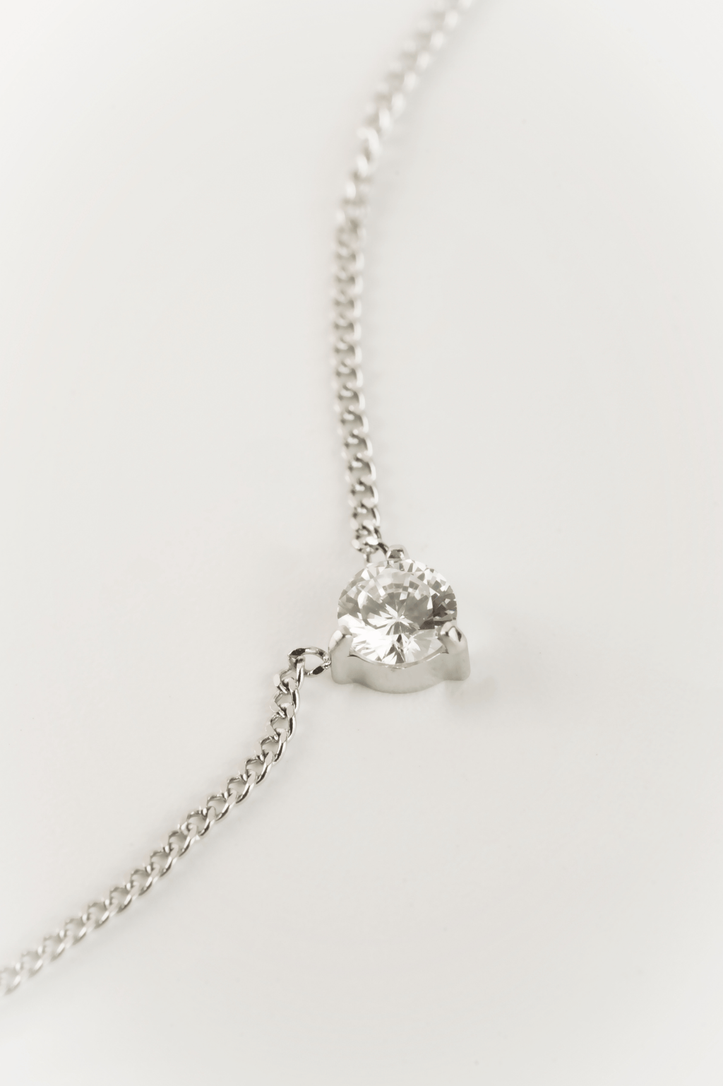 Close-up of three-prong 4mm CZ setting on MNML Pragma Solitaire Necklace — minimal solitaire detail