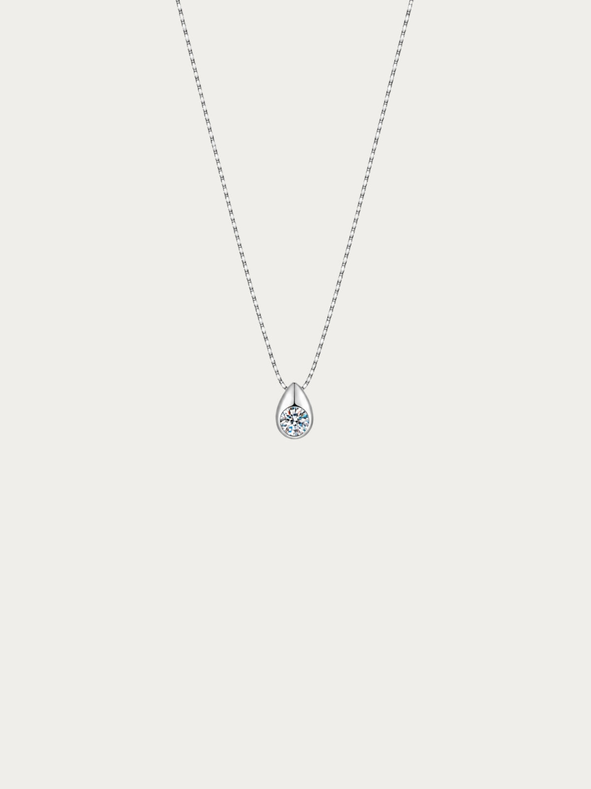 Reverie necklace with a round moissanite bezel-set in a teardrop on a 925 sterling silver box chain, front view