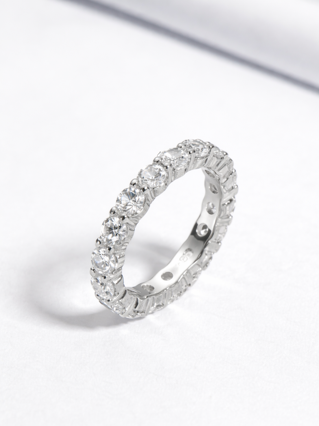 Close-up of round-cut stone facets on Rhea eternity band
