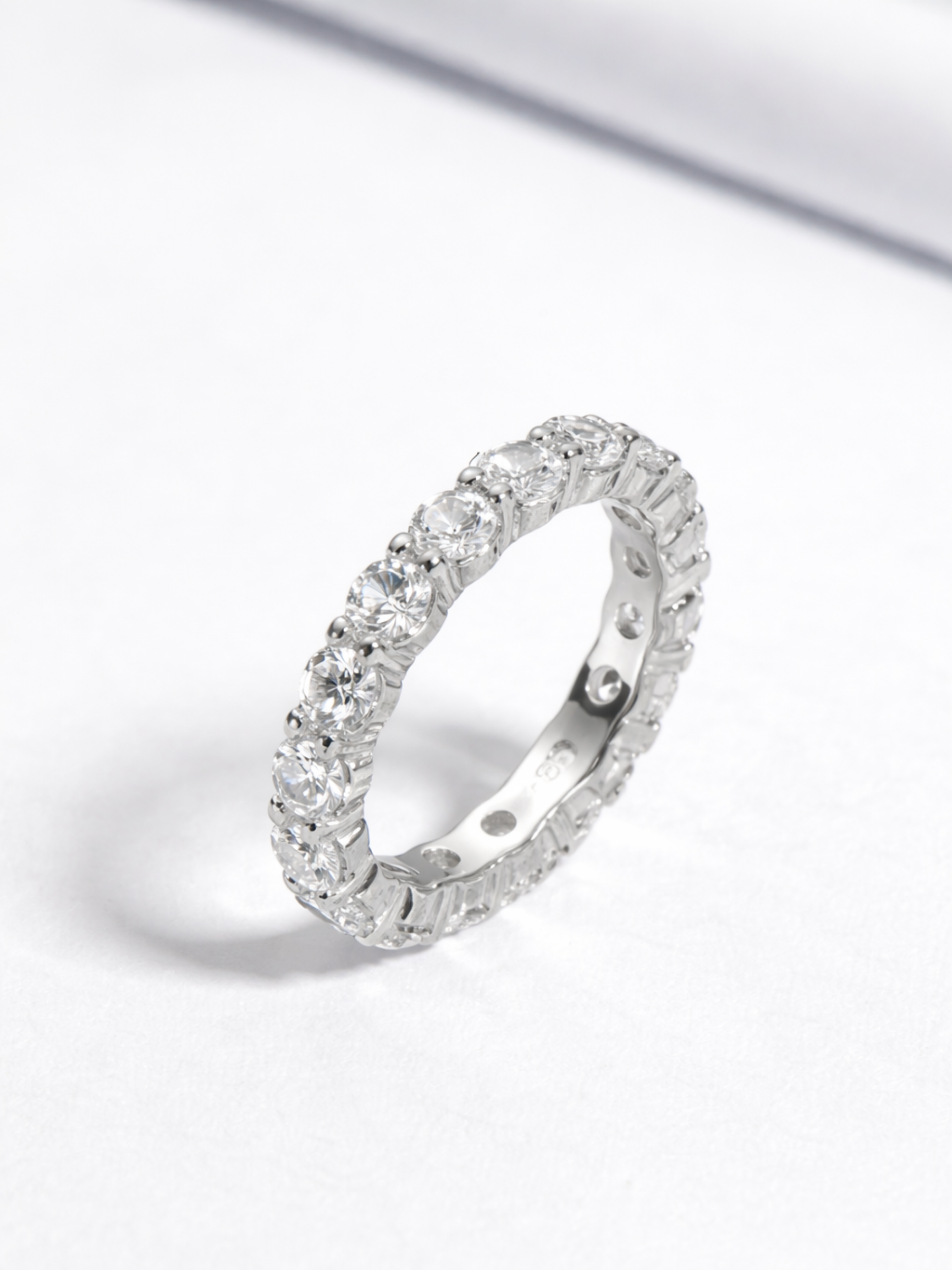 Close-up of round-cut stone facets on Rhea eternity band
