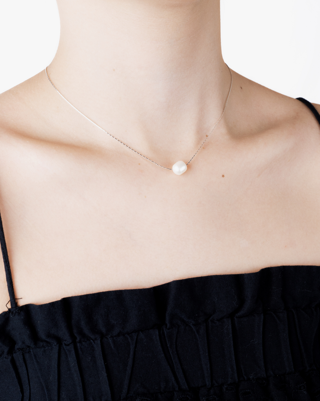 Rika pearl necklace worn on the neck, side view