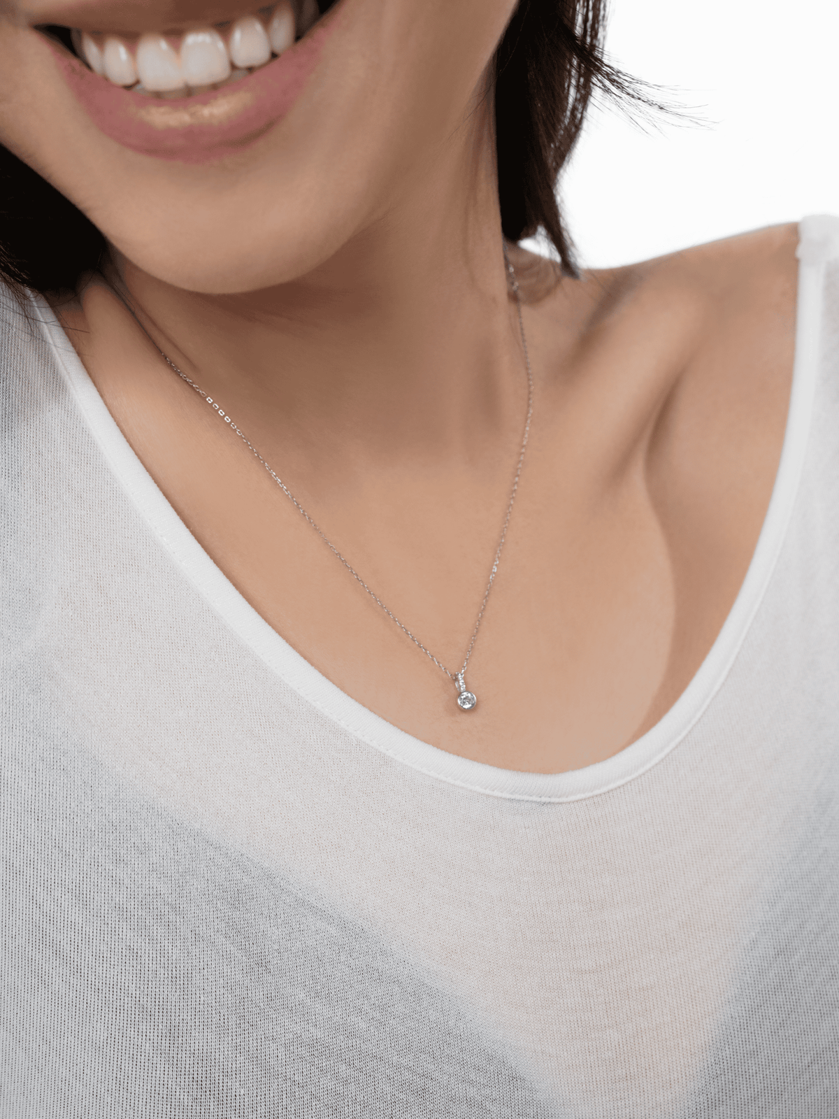 Close-up of the bezel-set round CZ and pavé bail accent on the Sunrise pendant